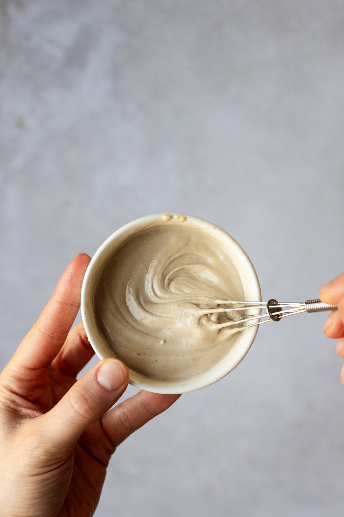 Whisking maple tahini sauce.