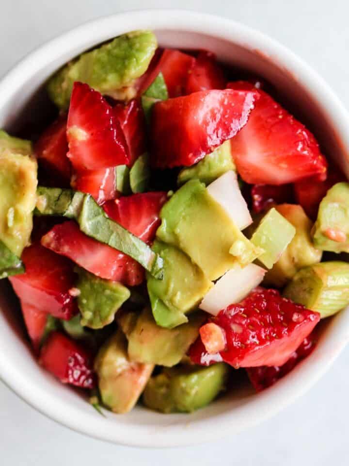 Strawberry avocado basil salsa in white bowl.