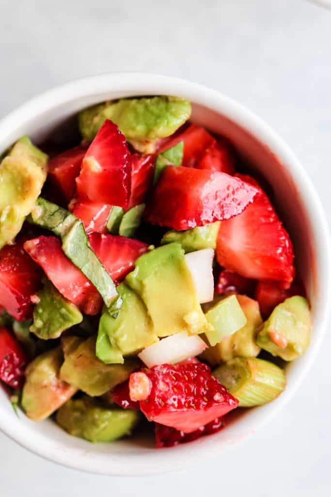 Strawberry avocado basil salsa in small white bowl