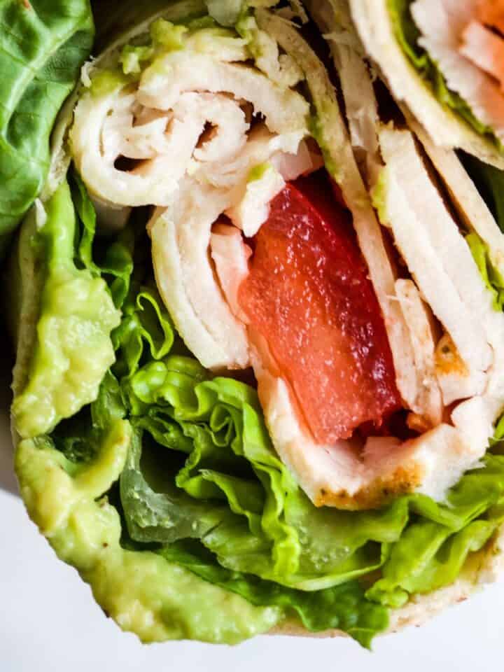 Whole wheat turkey wrap with avocado, lettuce, tomato, and turkey.