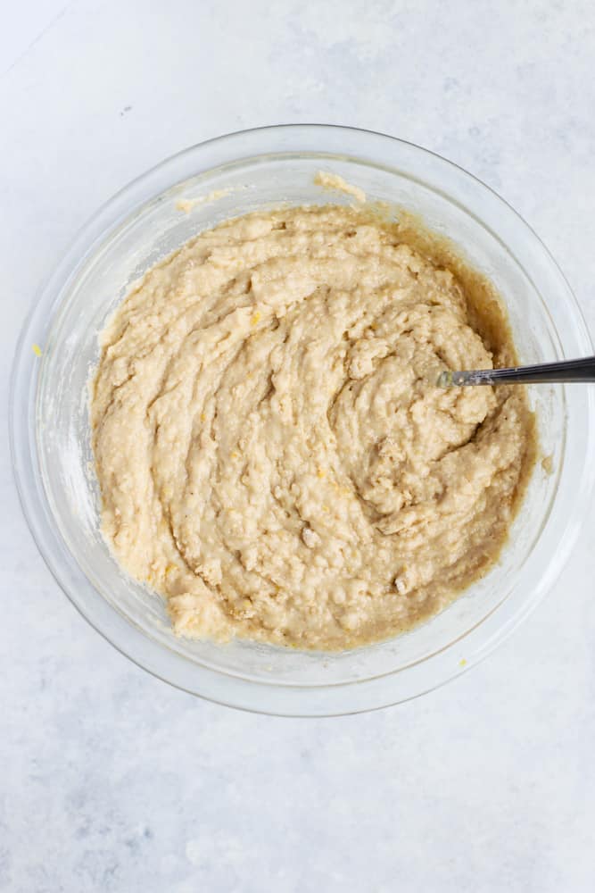 Raspberry lemon muffin batter mixed together in clear bowl with fork before adding raspberries