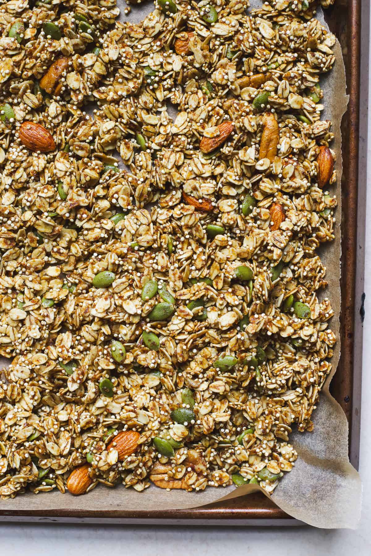 Baked pumpkin spice granola with pumpkin seeds in a sheet pan.