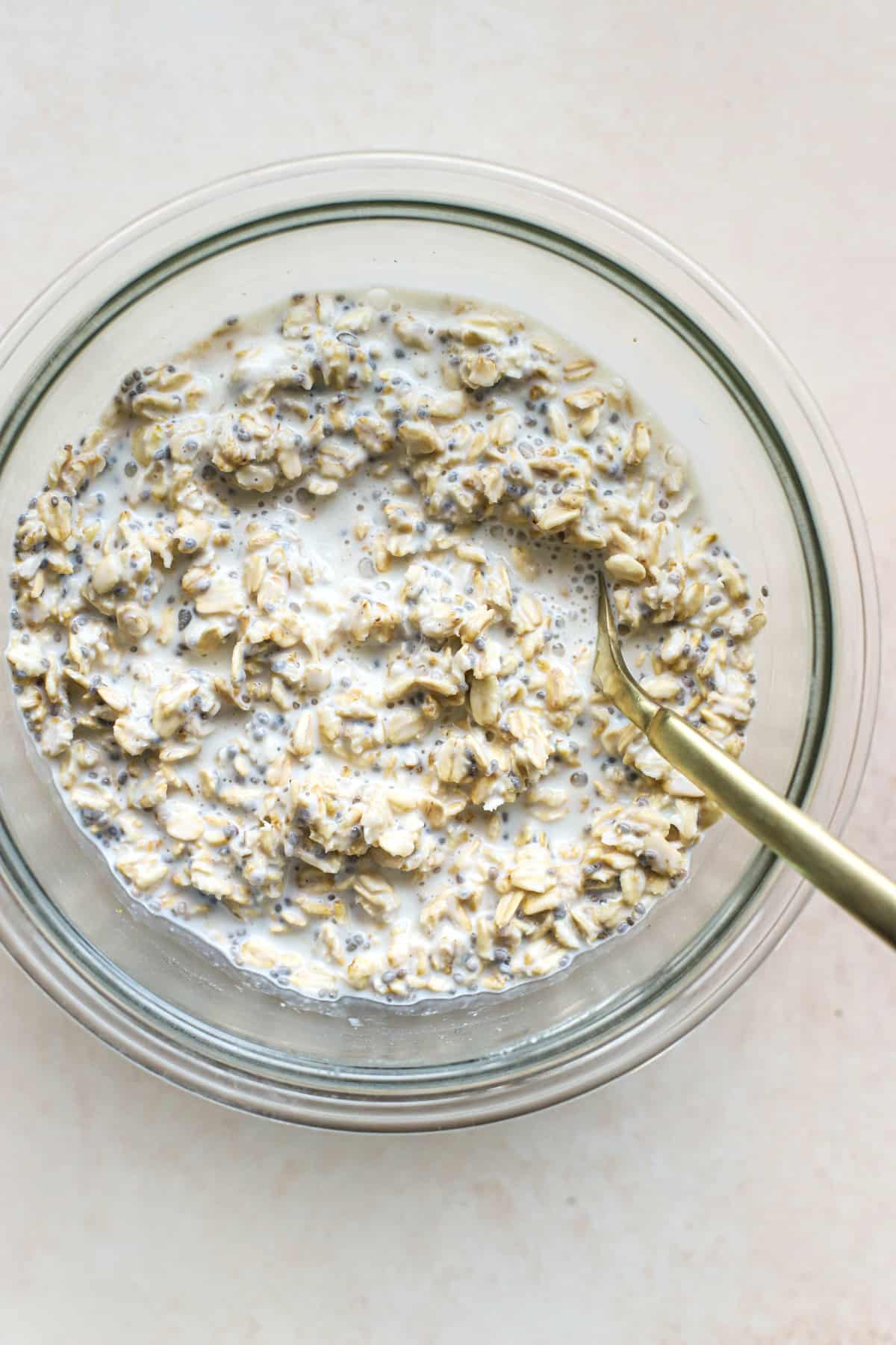 Fully chilled overnight oats in a bowl with a spoon.