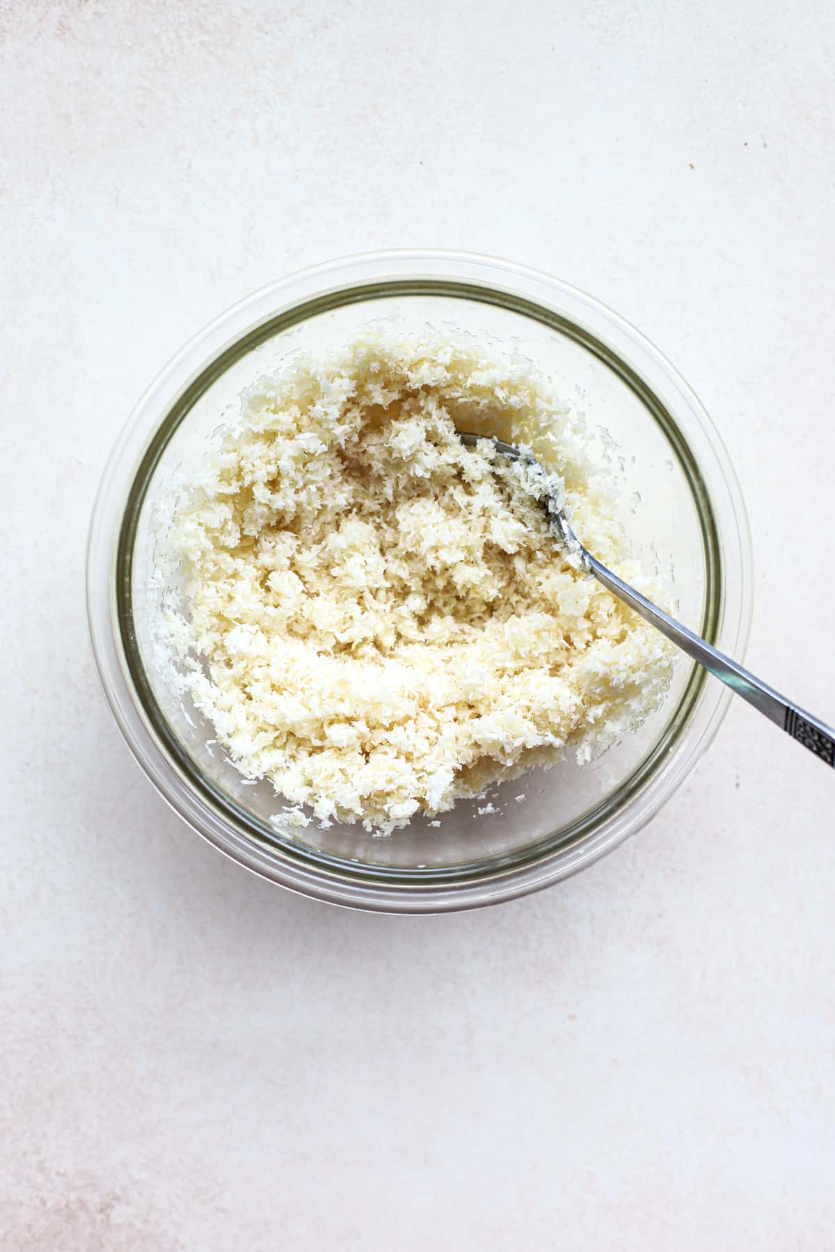 Macaroon filling ingredients mixed together in clear glass bowl with fork