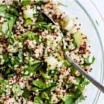 Quinoa cucumber salad in a bowl with herbs.