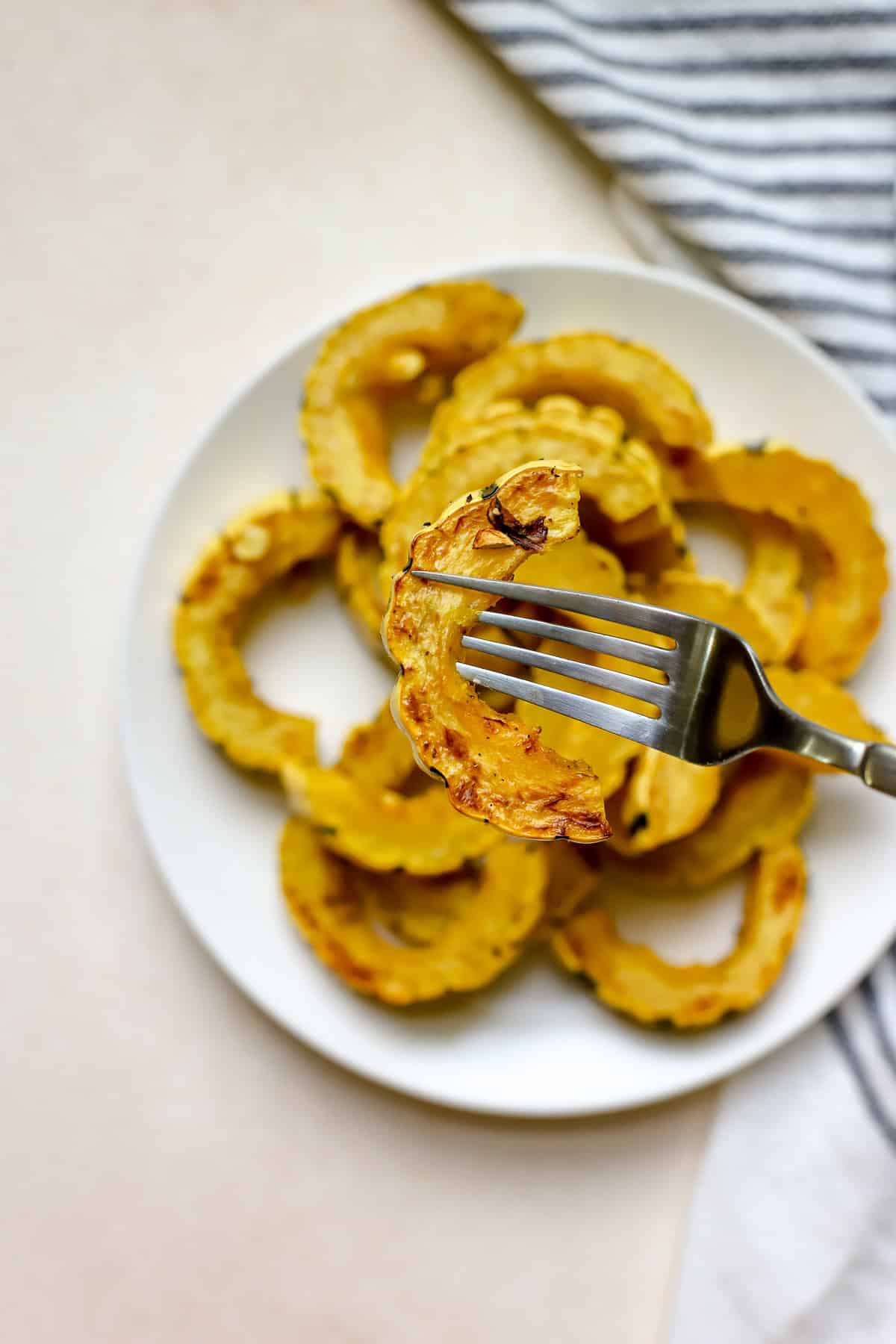 Slice of roasted delicata squash on fork.