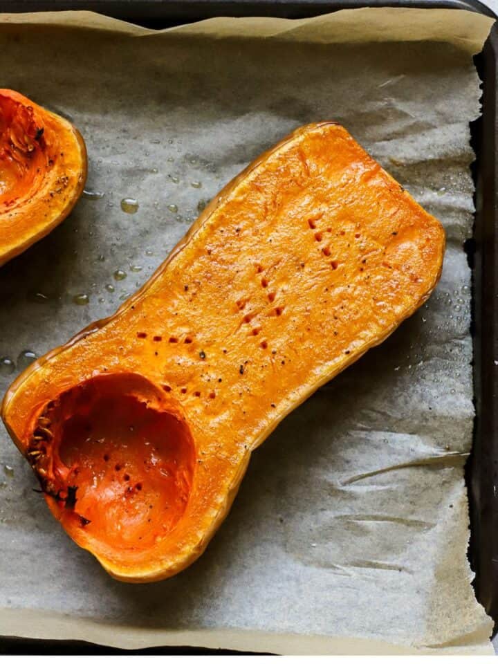 Roasted butternut squash half on sheet pan.