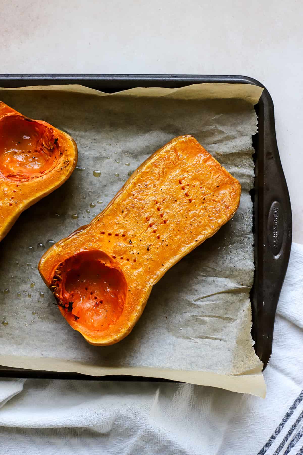 Roasted butternut squash half on sheet pan.