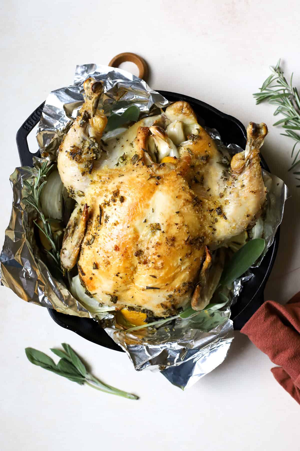 Simple roasted chicken with herbs in cast iron skillet.