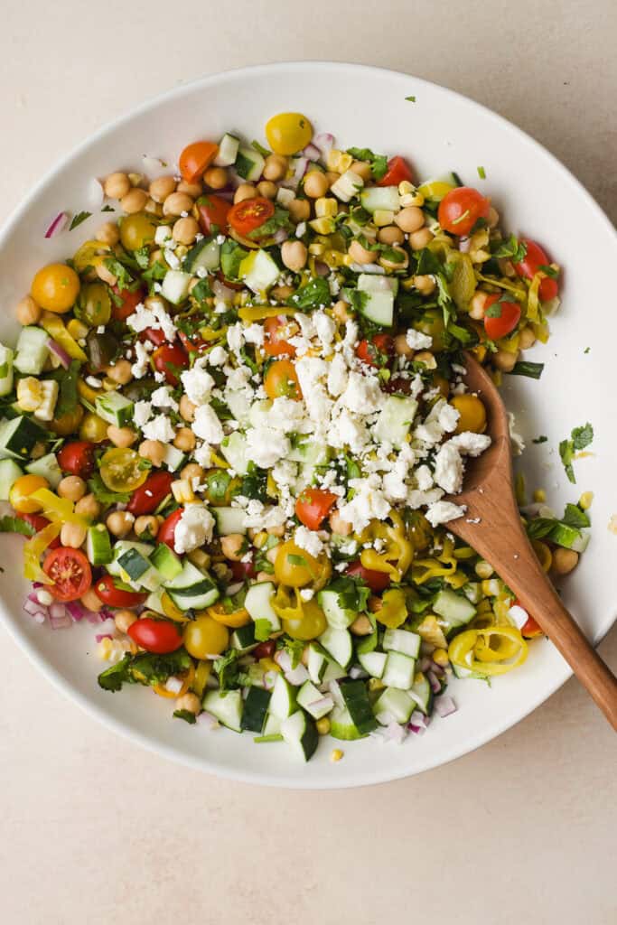 Large bowl of chickpea and tomato salad topped with feta.