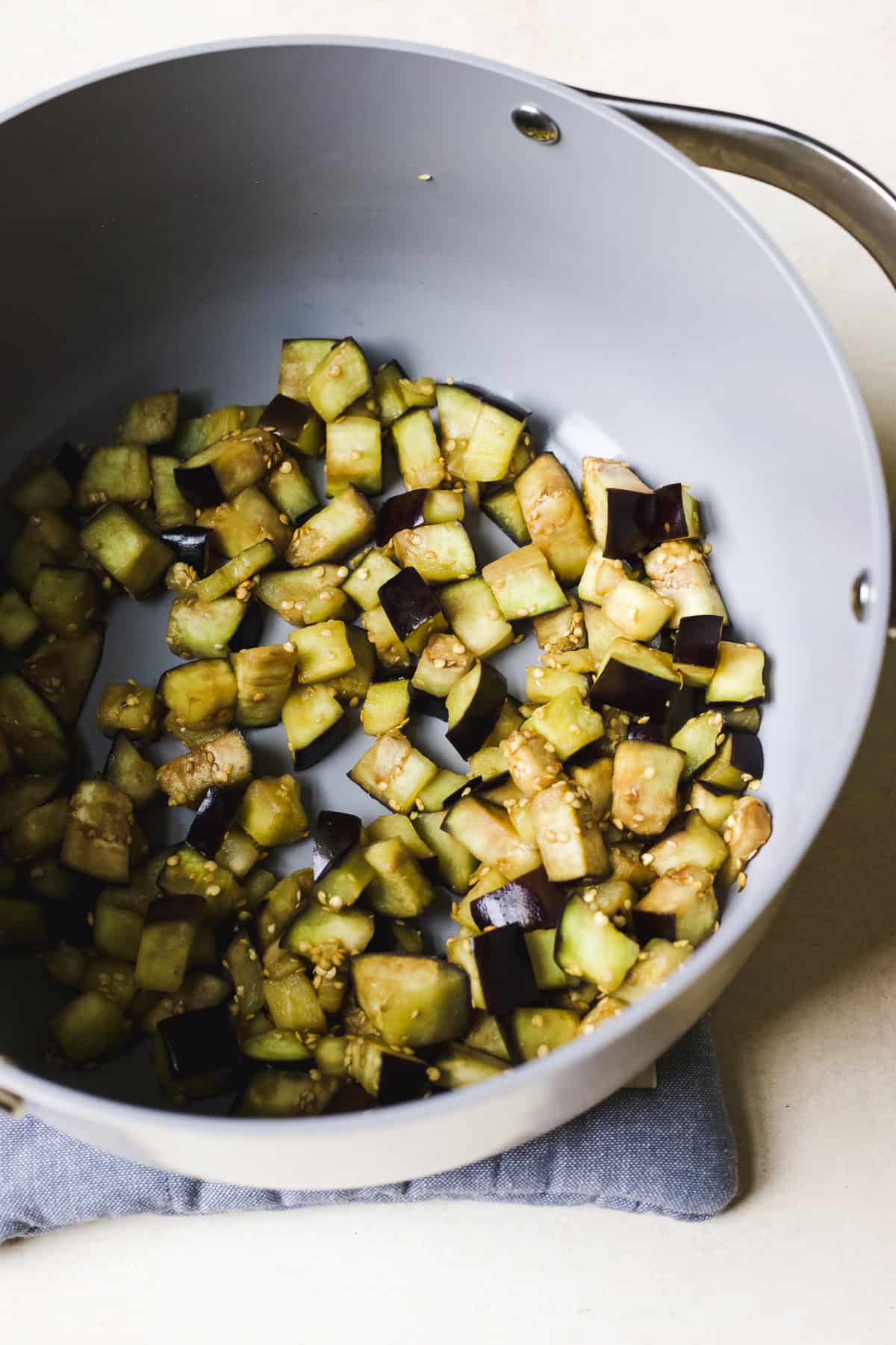 Sautéing eggplant cubes in a large pot.