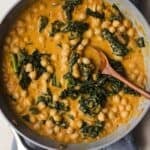Creamy pumpkin curry with chickpeas in skillet.