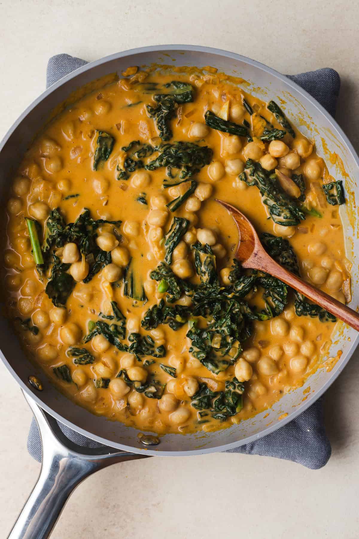 Creamy pumpkin curry with chickpeas in skillet.