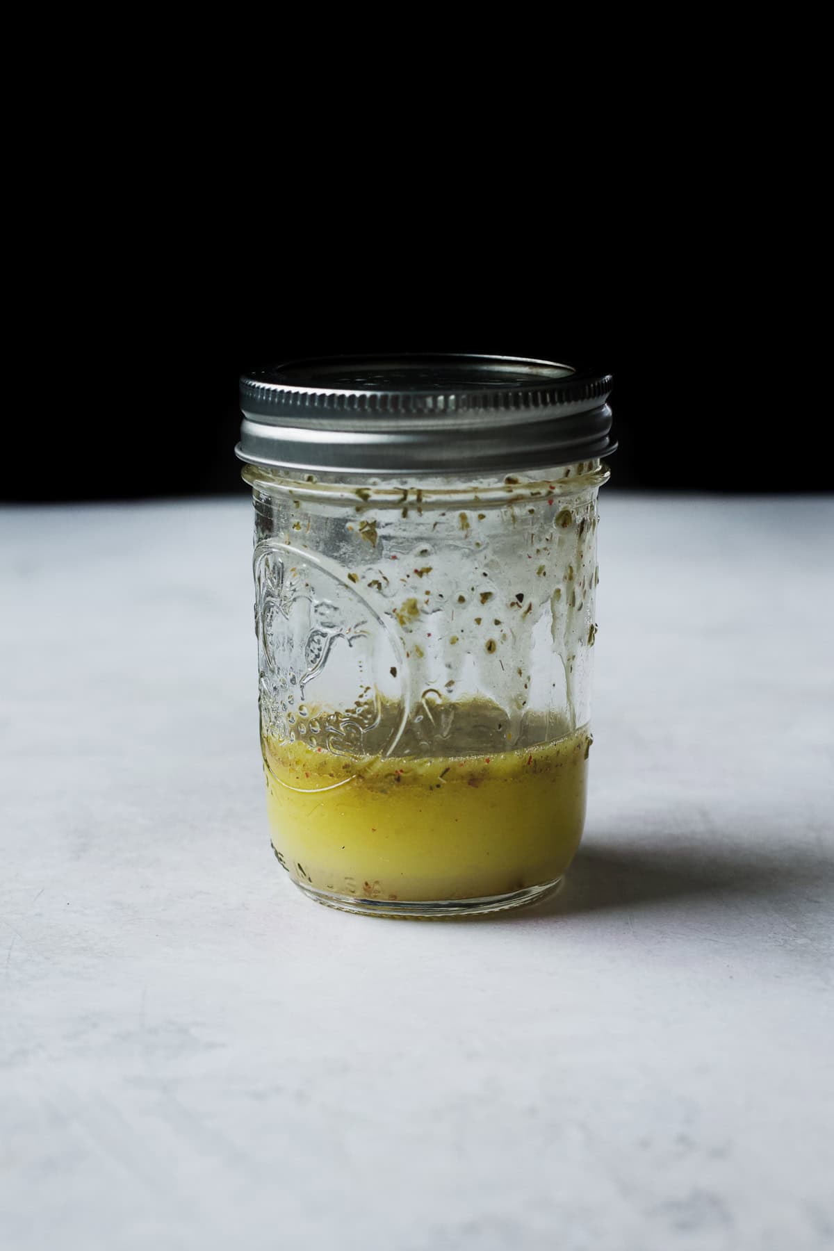 Simple Italian dressing with peperoncini brine in a glass jar.