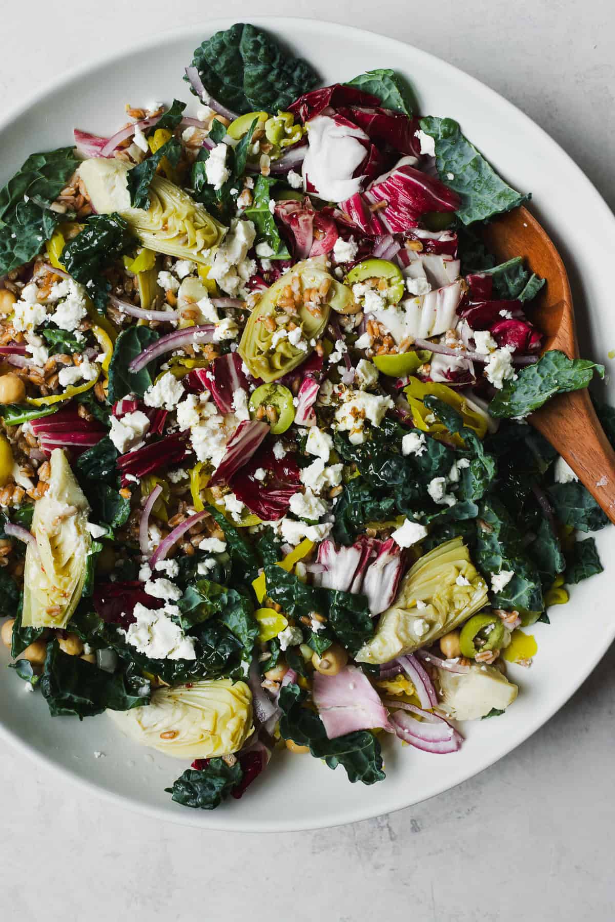 Kale farro salad tossed together in a large serving bowl.
