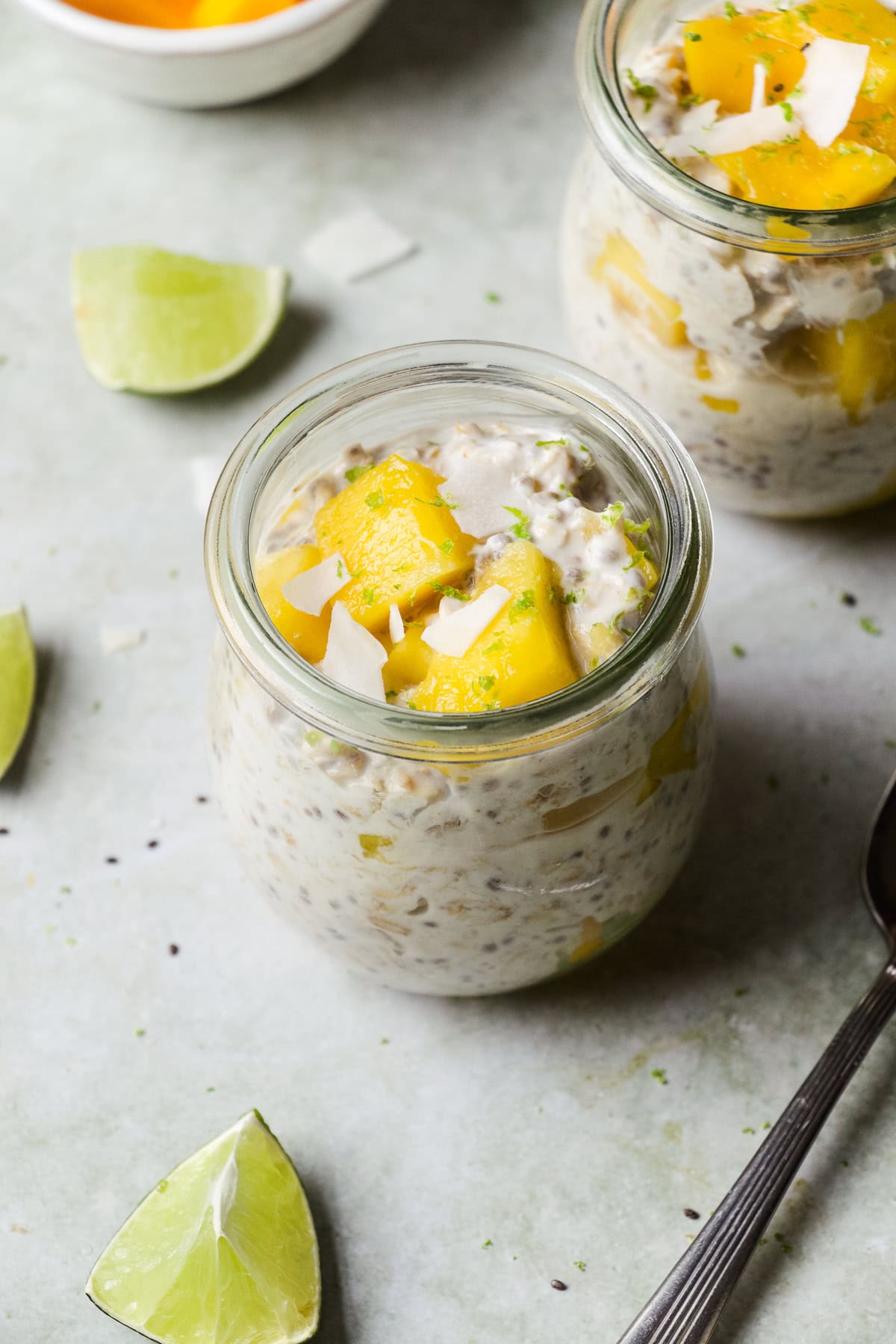 Mango overnight oats in a small jar with coconut on top.