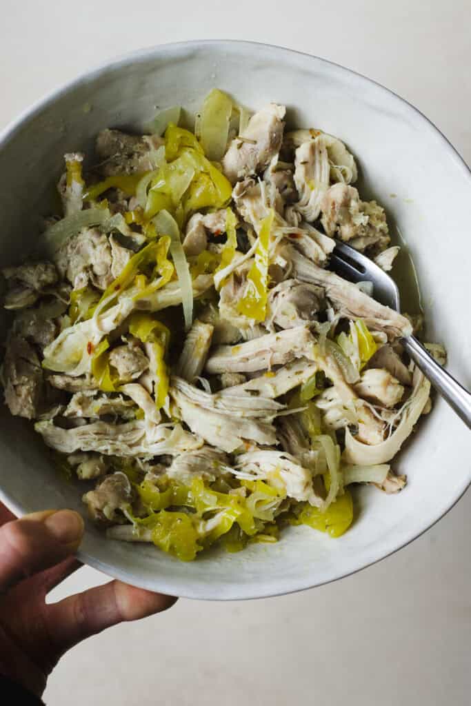 Instant Pot peperoncini chicken shredded in a bowl with a fork.