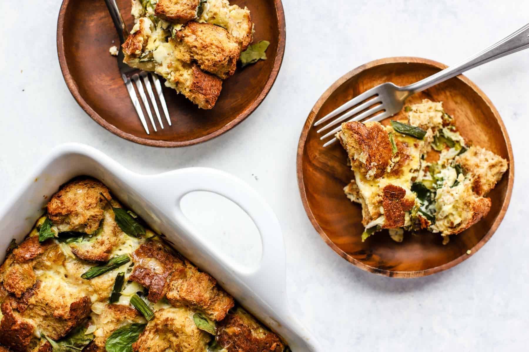 Healthy breakfast strata squares being served on plates with forks.
