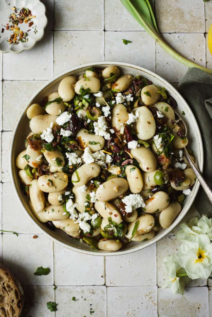 Marinated Royal Corona beans served in a bowl with a spoon.
