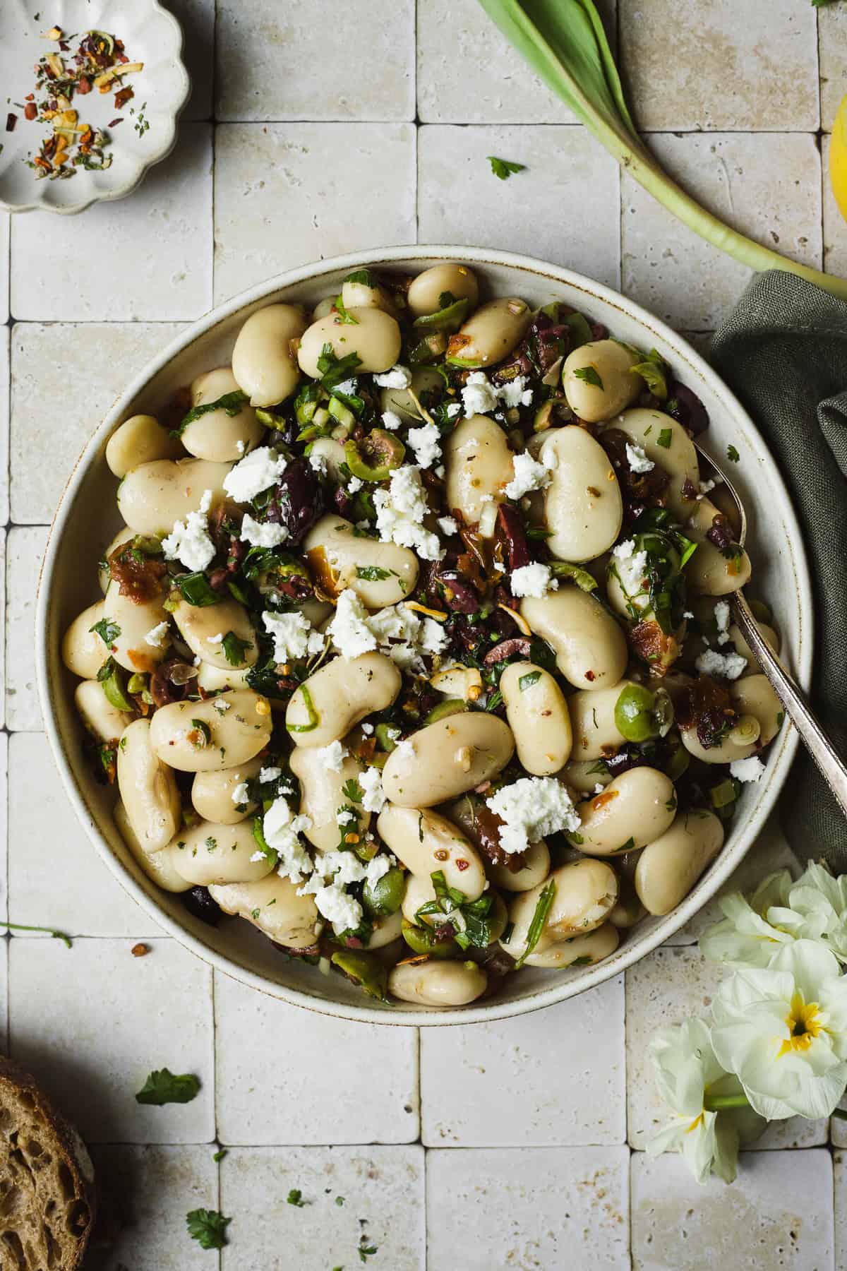 Marinated Royal Corona beans served in a bowl with a spoon.