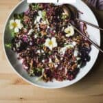 Cherry salad with wheat berries, feta, walnuts, and cherry vinaigrette in a serving bowl.
