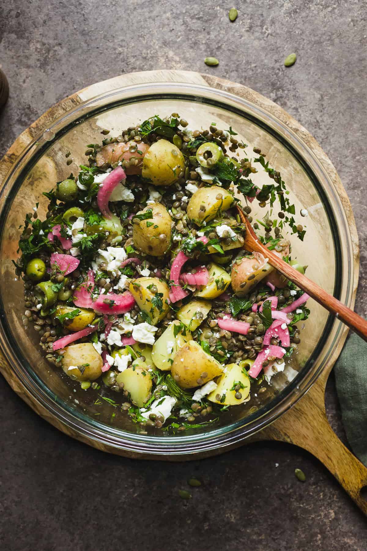 Warm lentil salad with feta and potatoes in a large bowl.