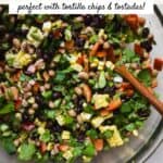 Black bean salad with corn in a large bowl with spoon.