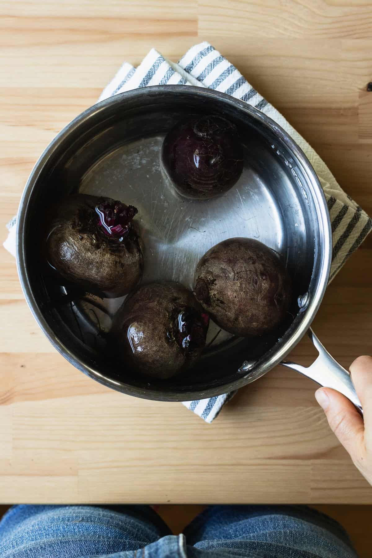 Boiling red beets in a pot.