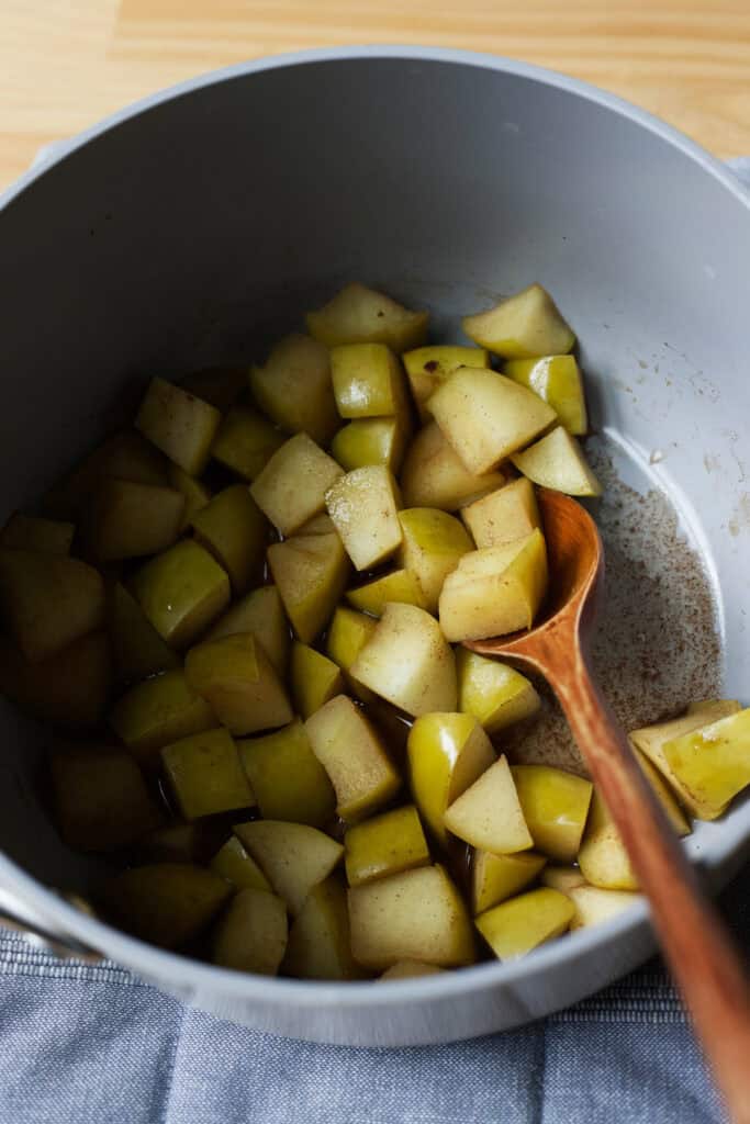 Stirring stewed apples in a pot.