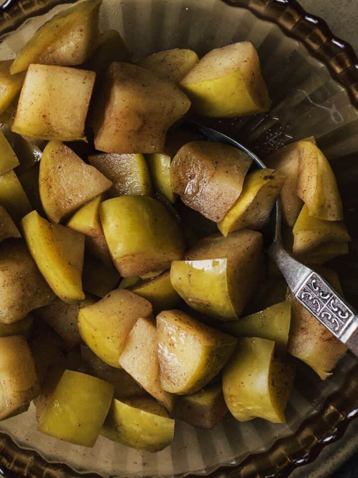 Cinnamon-spiked stewed apples in a bowl with a spoon.